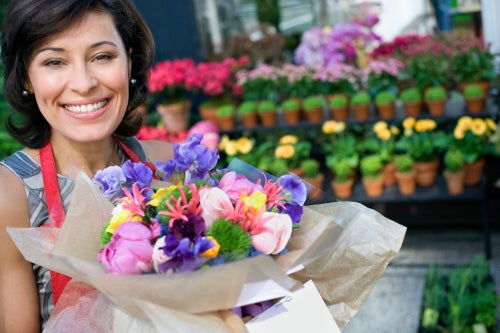 A florist showing a bouquet of colorful flowers
